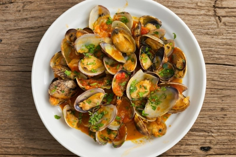 Delicioso platillo con almejas a la marinera en salsa roja ligada con perejil fresco.