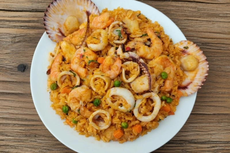 Delicioso arroz con mariscos servido en un plato colorido
