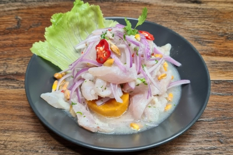 Ceviche de merluza fresco y delicioso sobre plato blanco